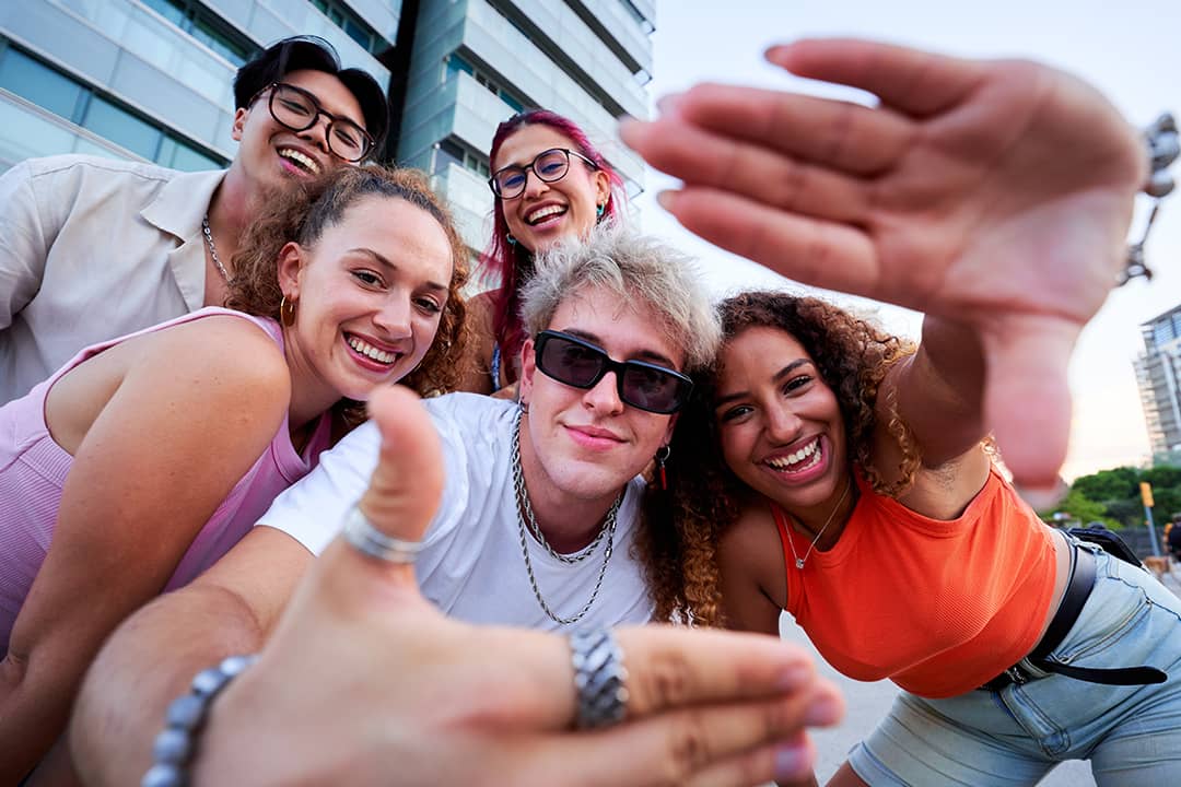 A group of Gen Z friends taking a selfie together outdoors.
